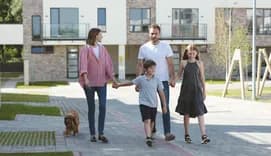 Family of four walking in front of appartment building