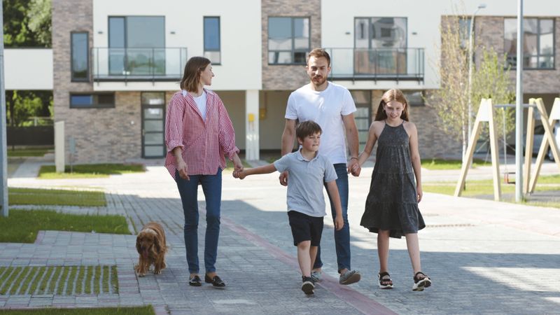 Family of four walking in front of appartment building