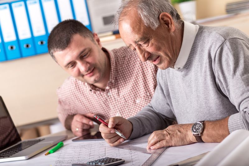 Two architects drawing at table