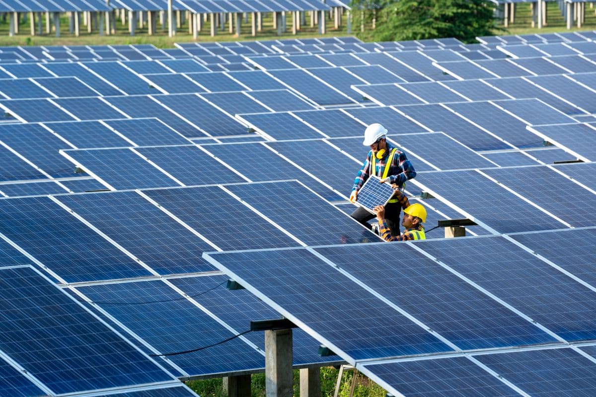 Engineers working on maintenance of solar batteries in solar power station